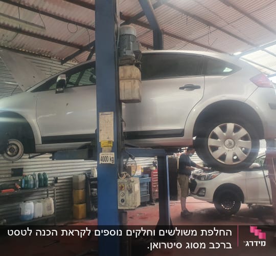 רכב מורם על ליפט במוסך עם גלגל חסר
